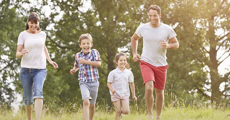 Familie läuft über eine Wiese